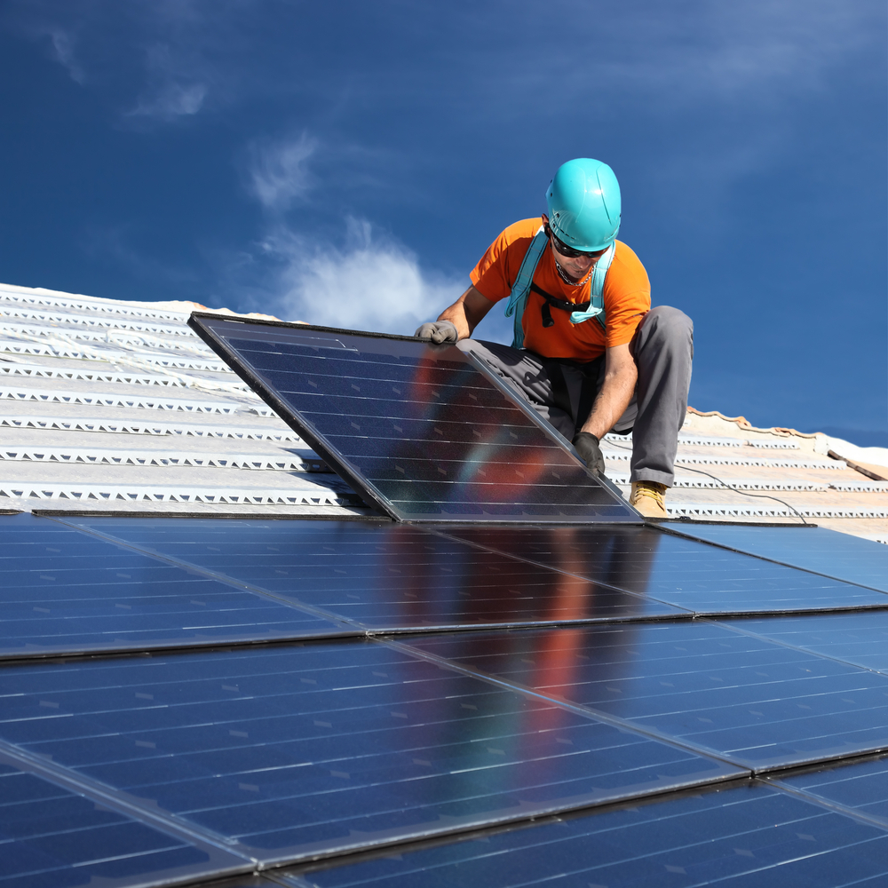 Man in Orange Installing Solar Panel — Roofing Services in Winnellie, NT